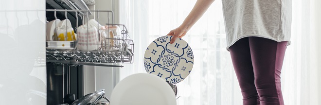 Woman using dishwasher, close up