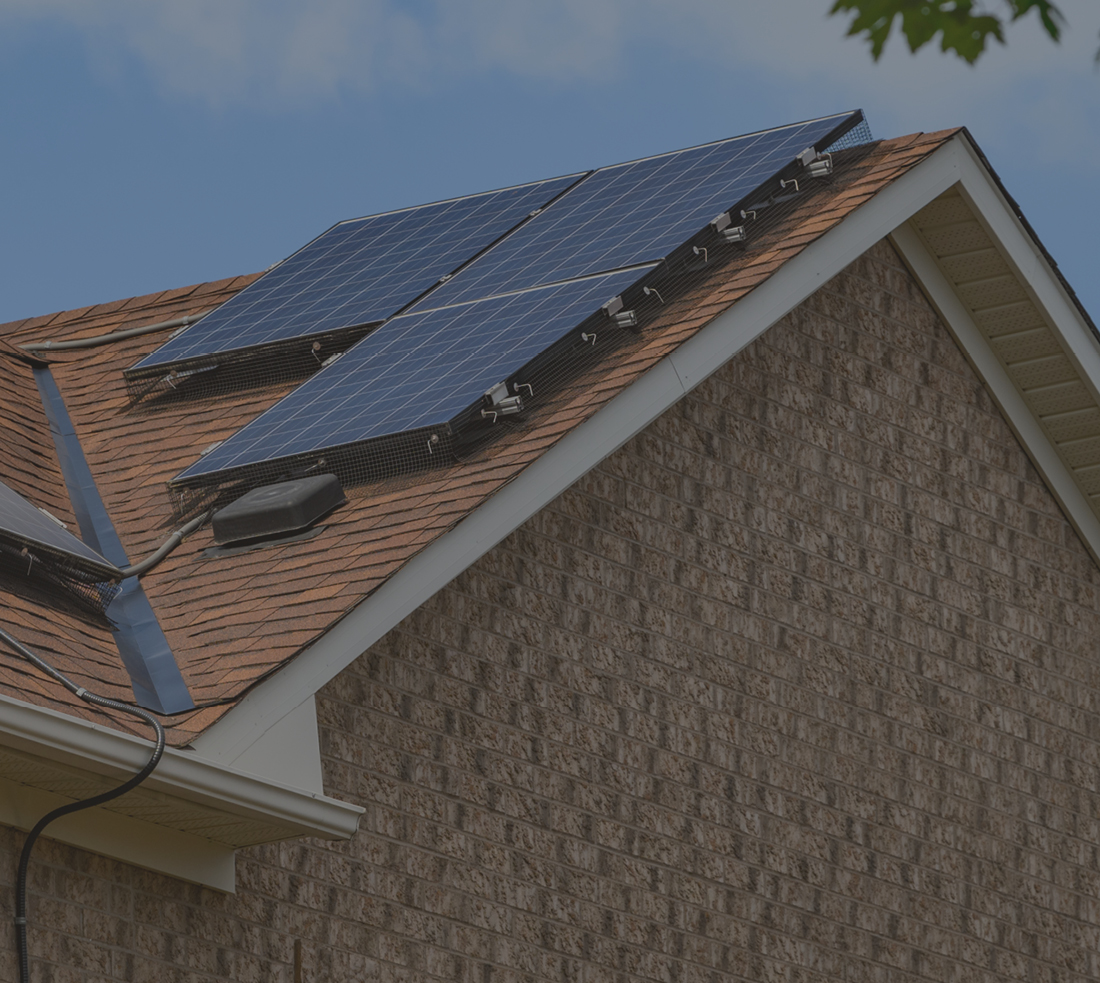Rooftop of a house with three solar panels on it 