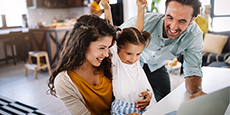 Happy family together looking at a computer screen.