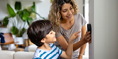 Woman and child adjusting a thermostat