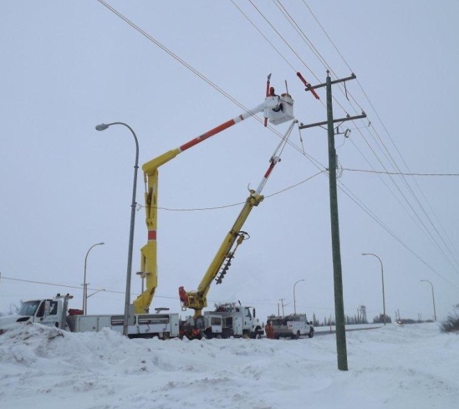 Bucket truck repairing a power pole on the Alaska highway in Fort St. John