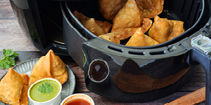 Close-up image of of cooking pan of fried samosas