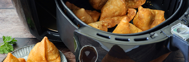 Close-up image of of cooking pan of fried samosas