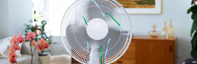 Female hand includes button on electric fan