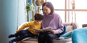 Mother and son are reading in the living room