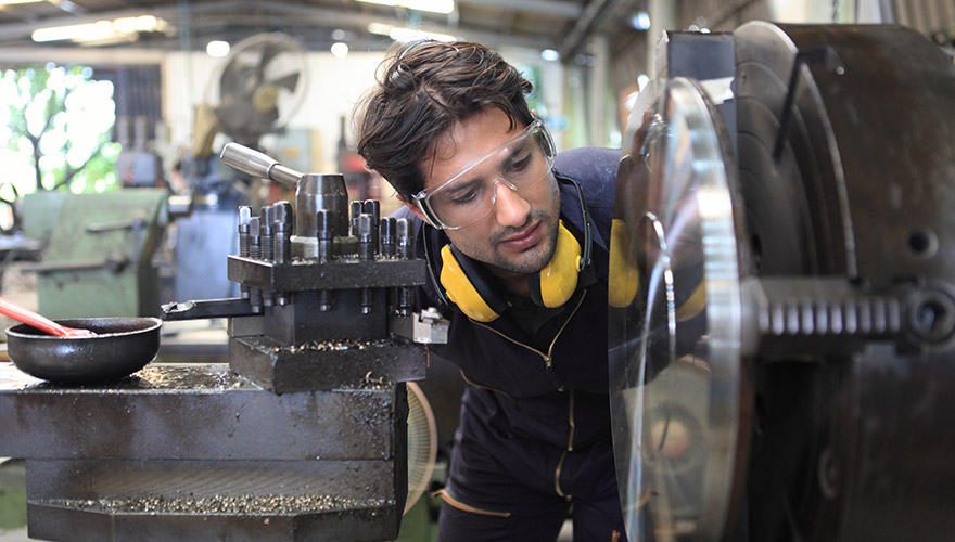 Factory engineer operating an industrial cutting machine