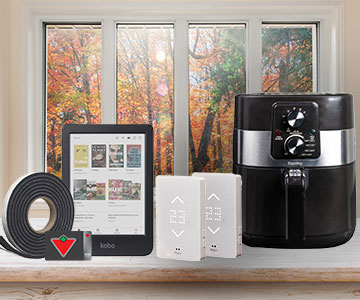 Weatherstripping tape, a Canadian Tire gift card, a Kobo e-reader, two MYSA smart thermostats, and an air fryer are pictured on a counter. An autumnal scene is seen in the windows in the background.