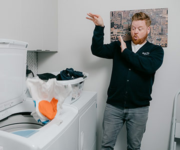Dave tossing laundry in a washing machine.