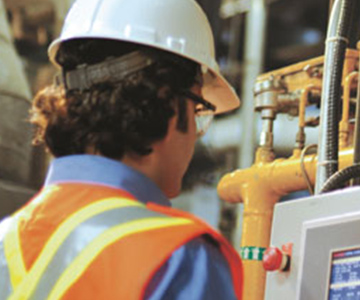 Worker at an industrial plant monitoring a screen