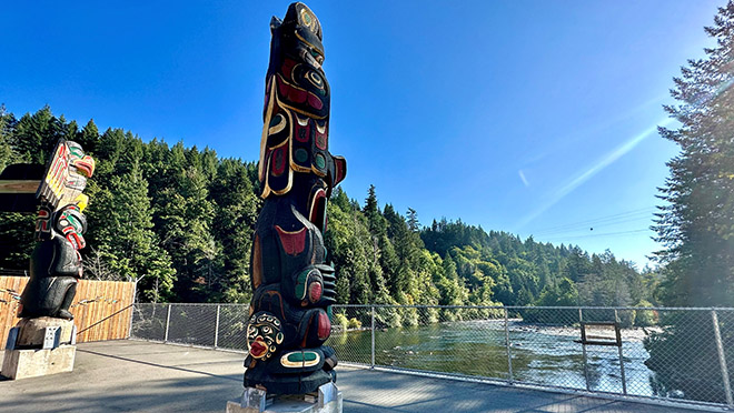 Wei Wai Kai and Wei Wai Kum totems looking out over the water.