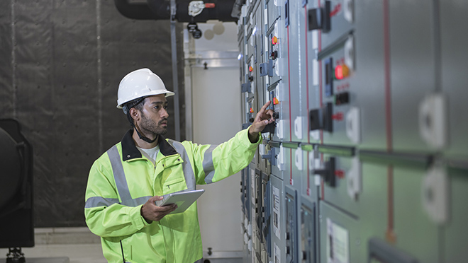 Male worker work on panel board in main distribution station room