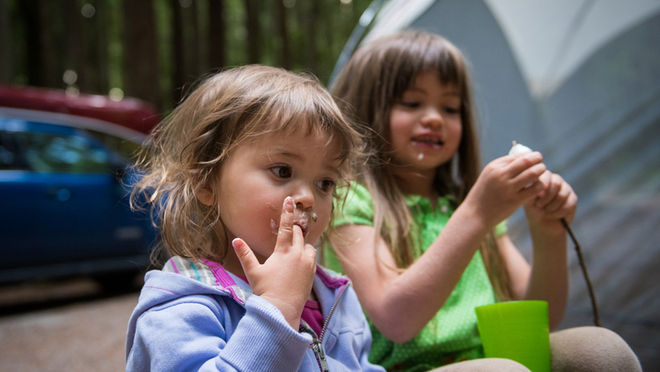 Children enjoying a snack at a campsite