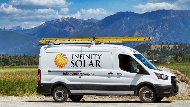 Infinity Solar service van parked in front of a mountain landscape.