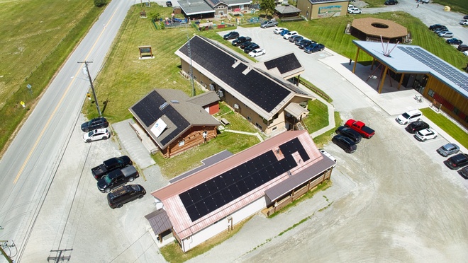 Aerial view of multiple buildings equipped with rooftop solar panels.