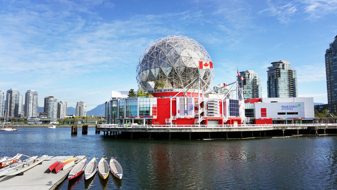 A giant geodesic dome stands beside the calm waters of False Creek.