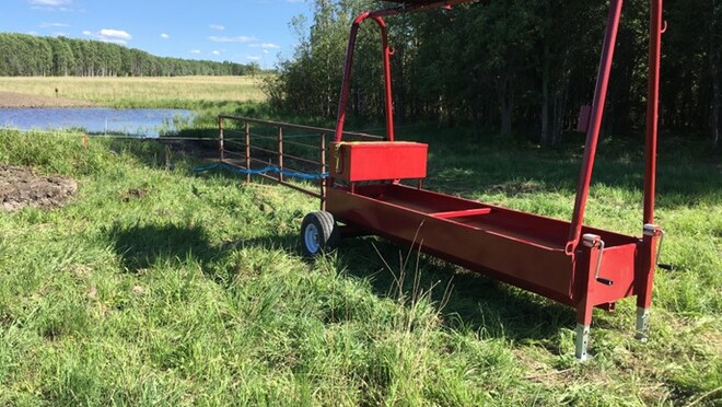 An open field with a pond, where a water buggy is drawing water.