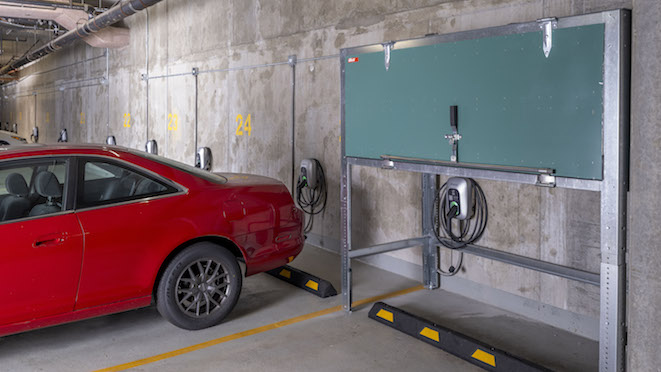 A red vehicle beside an EV charging spot